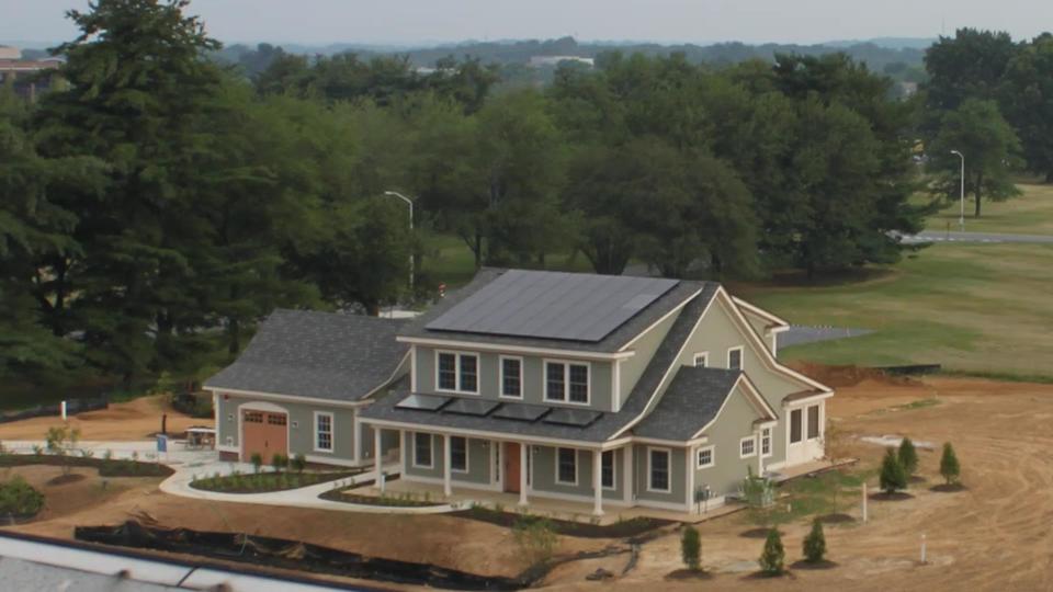 A newly built two-story home has solar panels on the roof.