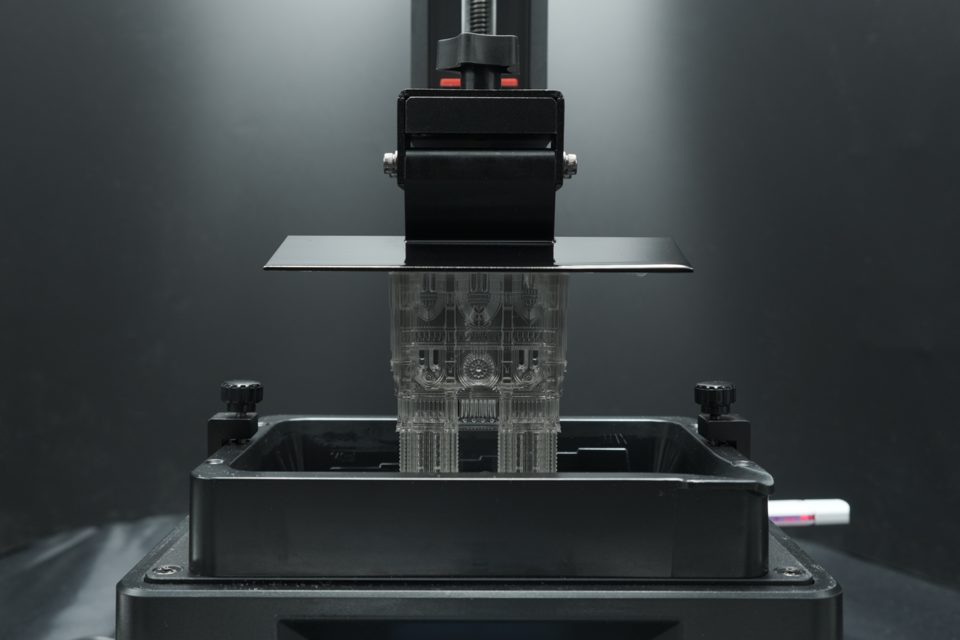 a complex architectural model is being produced by suspension in a vat of photopolymer resin and ultraviolet (UV) curing