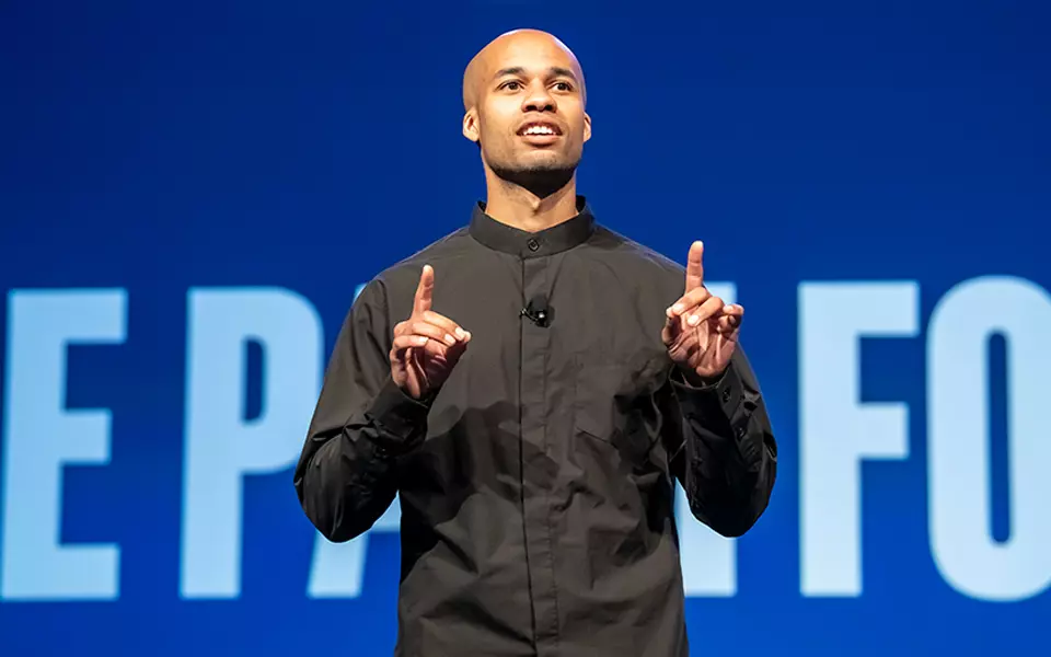 Tucker Bryant speaks on a stage in front of an audience.