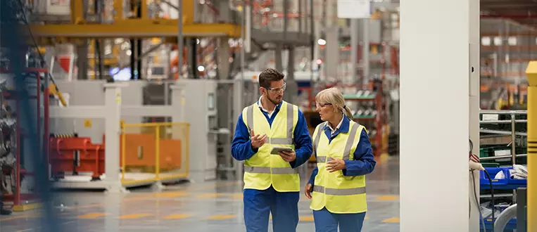 Workers walking through a factory having a discussion