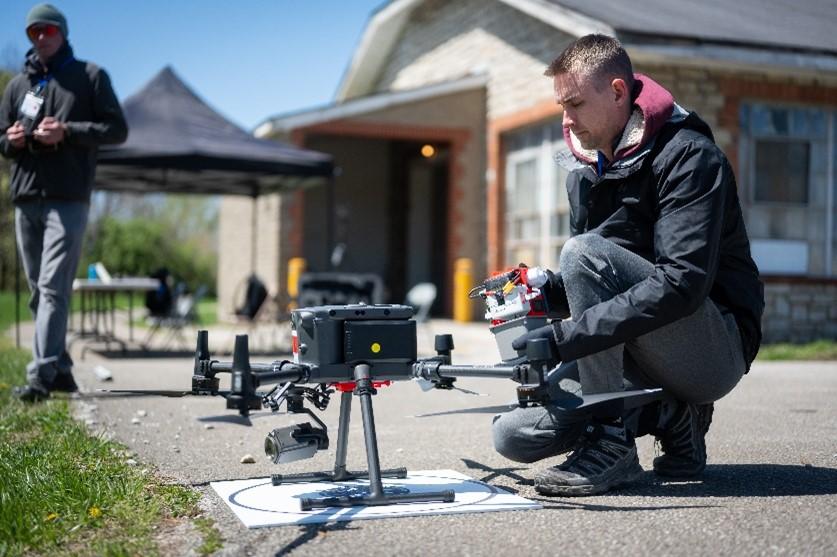 man kneeling in front of a drone