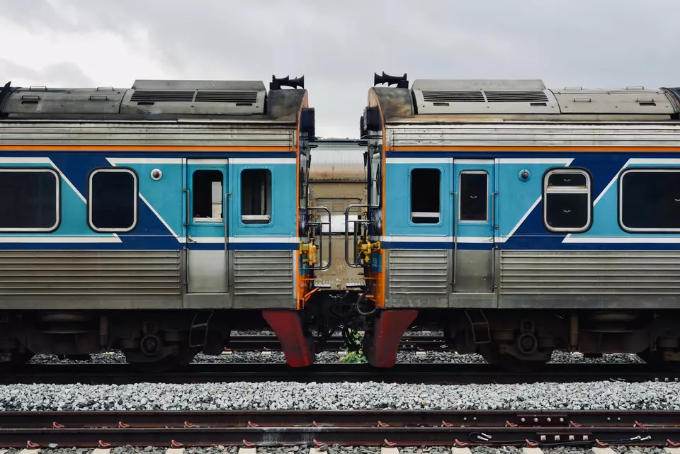 A detailed view of two connected blue and silver train cars on a railway track.