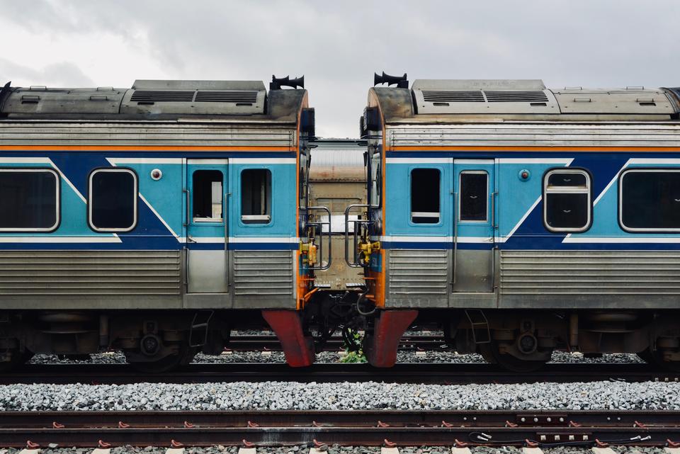 A detailed view of two connected blue and silver train cars on a railway track.