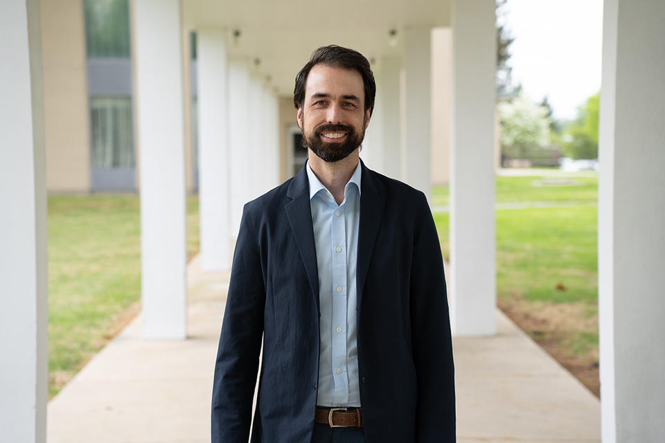 Corey Stambaugh poses smiling outdoors on the NIST campus.