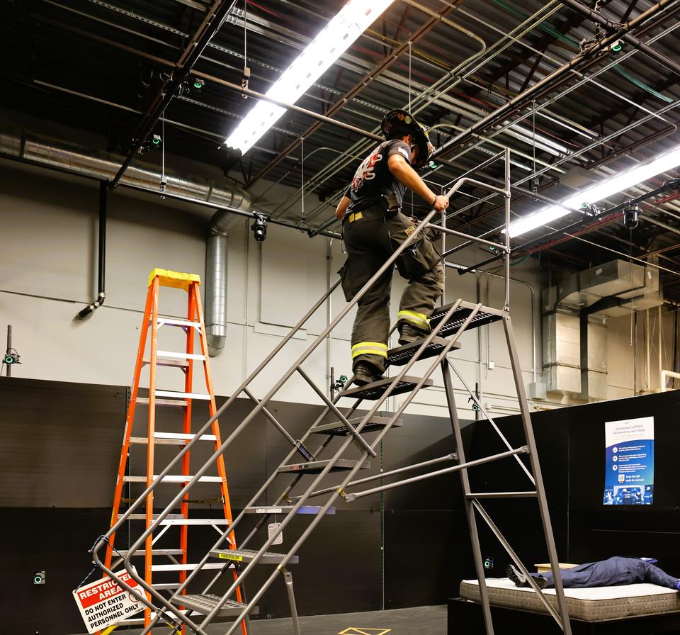 Firefighter in the PSITC climbs up a staircase during training session
