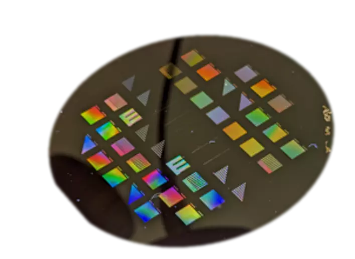 Black disk has multicolored squares and triangles on its surface. 