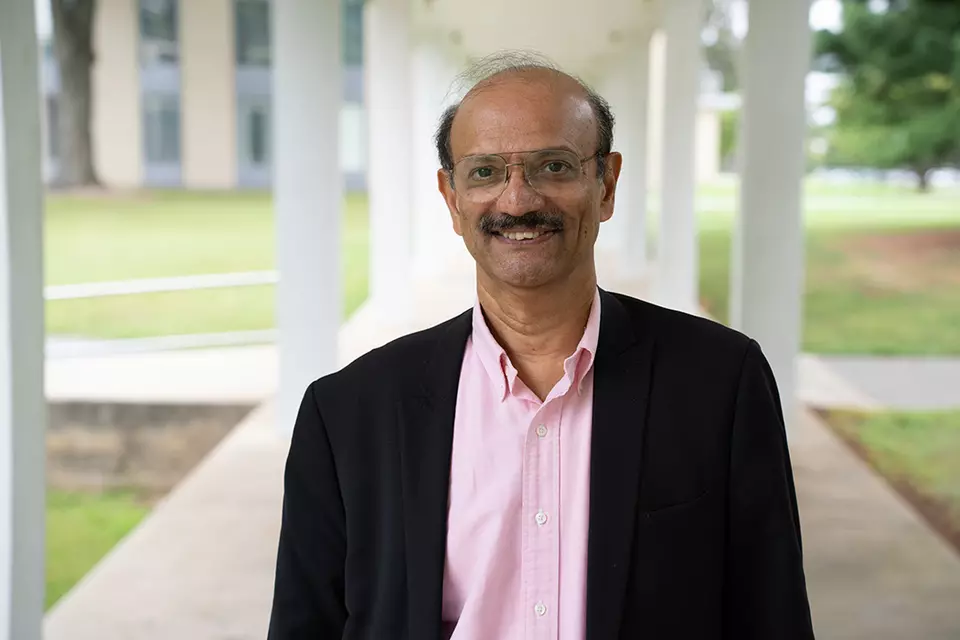 Ram Sriram poses smiling for a head shot outdoors on the NIST campus.