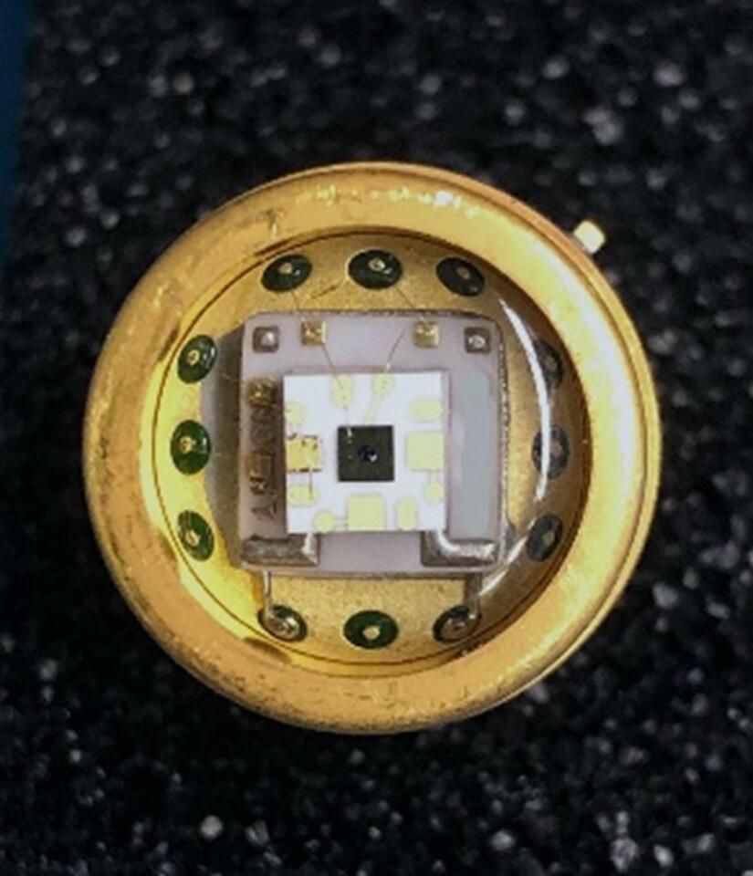 Square chip is fixed to a round metal surface. 