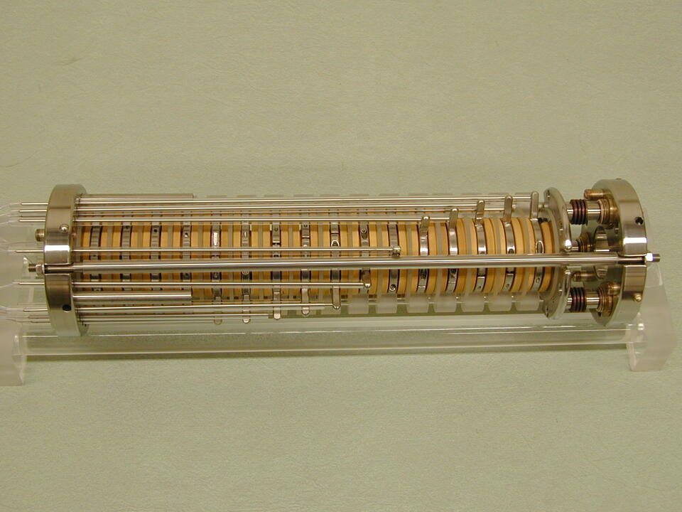 A cylindrical device is made up of adjustable disks with metal attachments on either end. 