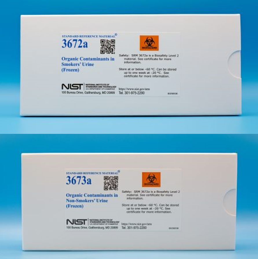 Two white cardboard boxes with white labels that contain blue text that reads  "Organic contaminants in smokers' urine"  One box displays Standard reference material 3672a and other 3673a