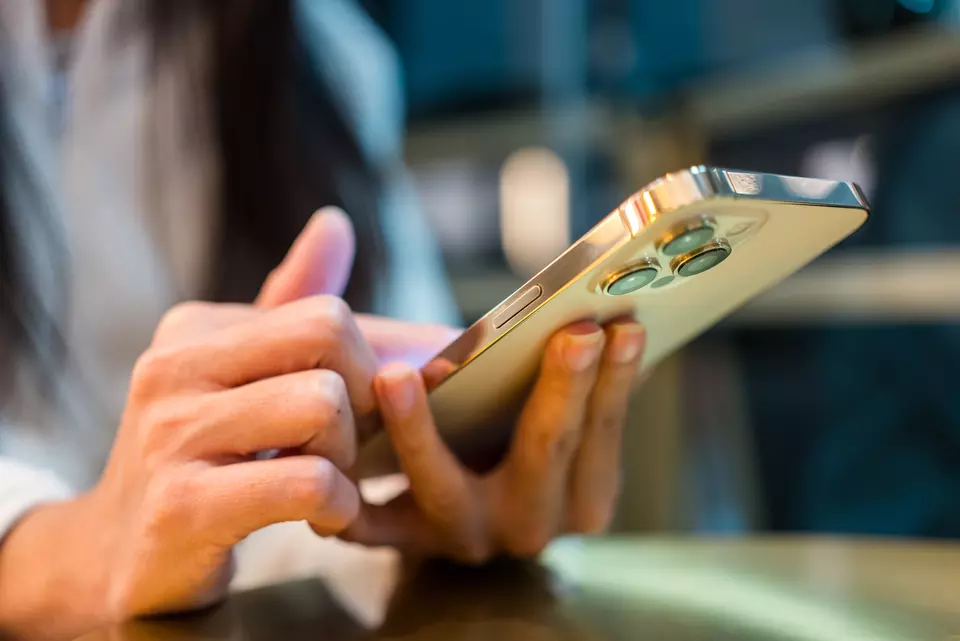 Closeup view of a smartphone held in a person's hands as they look at the screen.. 
