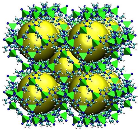 Illustration with five yellow spheres arranged with body centered cubic orientation, and surrounded by small green tetrahedrons and molecules to represent the metallic organic framework structure.