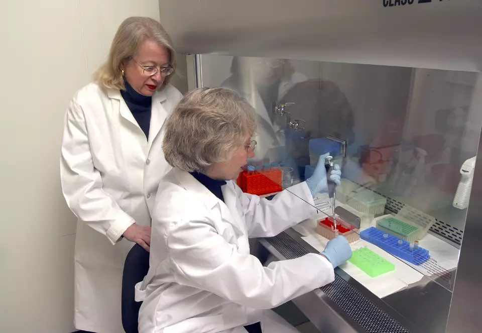 Two women at a lab hood
