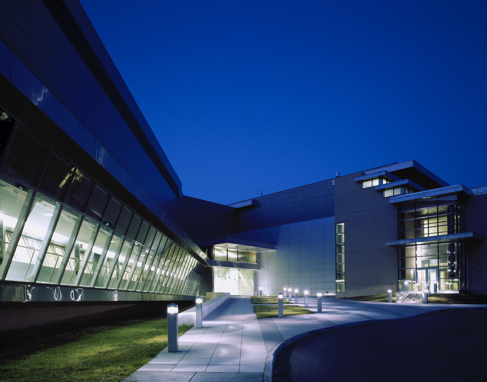 night view of AML building. Dark blue sky. Lights on inside the building.