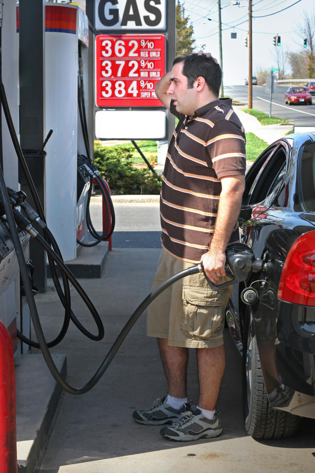 Man standing at a gas pump