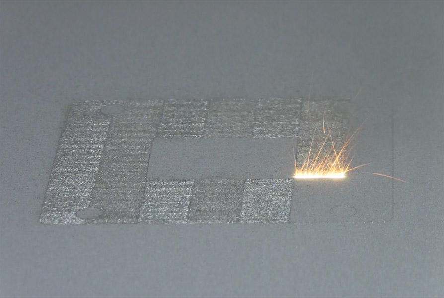 A high-power laser spot scans back and forth over a layer of cobalt-chrome powder on NIST's powder bed fusion additive manufacturing machine. Where it touches, the powder melts and fuses to underlying layers until a fully dense 3D metal part is formed. The laser travels back and forth so fast that, in this still image frame, it appears to form a white hot stripe about 10 millimeters wide.