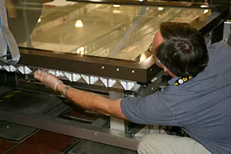 NIST technician Dana Strawbridge bolts the top frame of the map encasement to its base during a test sealing of the encasement prior to shipping to the Library of Congress.