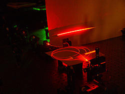 Laser light travels through an optical fiber, built at NIST, possessing a special microscopic structure that helps produce large yields of paired light particles that may be suitable for future quantum communications.