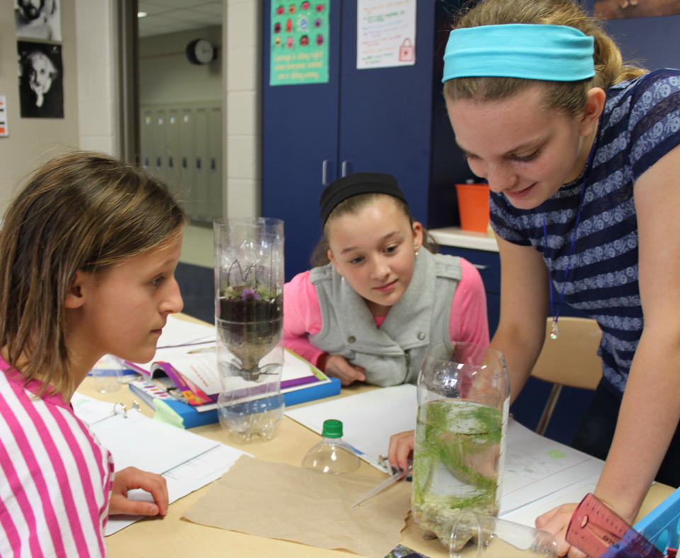 Pewaukee School District photo of three students doing science experiment.