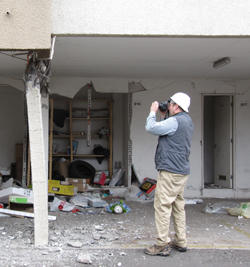 NIST researcher, Jeff Dragovich, documenting structural damage in the city of Concepcion from the 2010 Chile Earthquake.