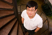 Jun Ye standing on a staircase