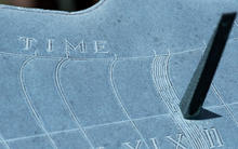 sundial in NIST Gaithersburg courtyard. The gnomon, several hour markers and the word "time" are visible. 