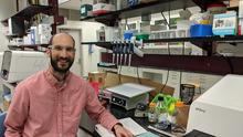 Justin Zook in a lab surrounded by genetic sequencing machines