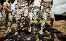 soldiers running through a tire obstacle at boot camp