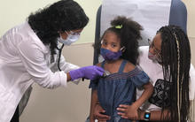 GMBC HealthCare System 2020 Baldrige Award Recipient in Health Care doctor listening to a toddlers heart that is sitting on her mother's lap.