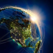 Highly detailed planet Earth at night, lit by the rising sun, illuminated by light of cities. Earth is surrounded by a luminous network, representing the major air routes based on real data