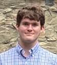 Headshot of a person standing in front of a textured nature background