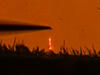 Optically pumped GaN nanowire laser shown glowing orange. 