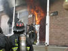 Flames from a living-room pour out the front door of a townhouse during a NIST test.