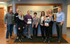 Baldrige Examiner Dawn Garcia with a group of coworkers in Wisconsin holding Baldrige framework booklet.