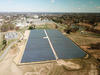 View from above, taken by a drone, of large array of solar panels on the campus of NIST near buildings and parking lots 