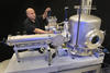 Man standing behind big silver equipment