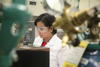 woman stands at mass spectrometer machine