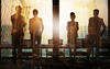 Four people at work in large building looking out at their future in the city skyline.