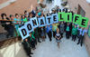 CORE staff celebrates National Blue & Green Day at their headquarters in Pittsburgh, PA by holding up signs spelling Donate Life.