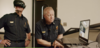 This image shows two first responders in uniform, one is observing a laptop and the other is wearing a VR headset.