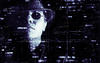 female face against a black background littered with bits of computer code. The woman is wearing a hat and sunglasses. There is a string of code coming from her mouth that looks like a cigarette.