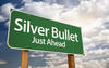 Silver Bullet Just Ahead green road sign with clouds and the sky in the background.