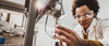 Black female engineer working on industrial machine in a laboratory