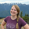 woman in a purple shirt against a backdrop of mountains