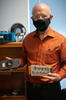 Paul Black poses holding vintage computing devices.