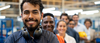 Cheerful blue collar worker and team of engineers at a factory standing in a row smiling at camera