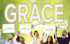 Our organization offers you GRACE (showing employees holding signs for gratitude, resilience, aspiration, courage, and  empathy)