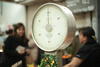 Photo of Produce Scale in Grocery Store with blurred image of two women in background
