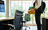 Who Will Return to the Workplace showing a man standing with a box of his belongings in front of an empty desk.