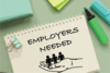 Text "employers needed" written on a notebook
